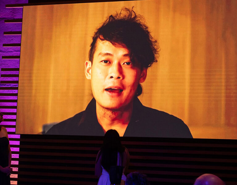 Bob Nguyen on a large screen accepting his award