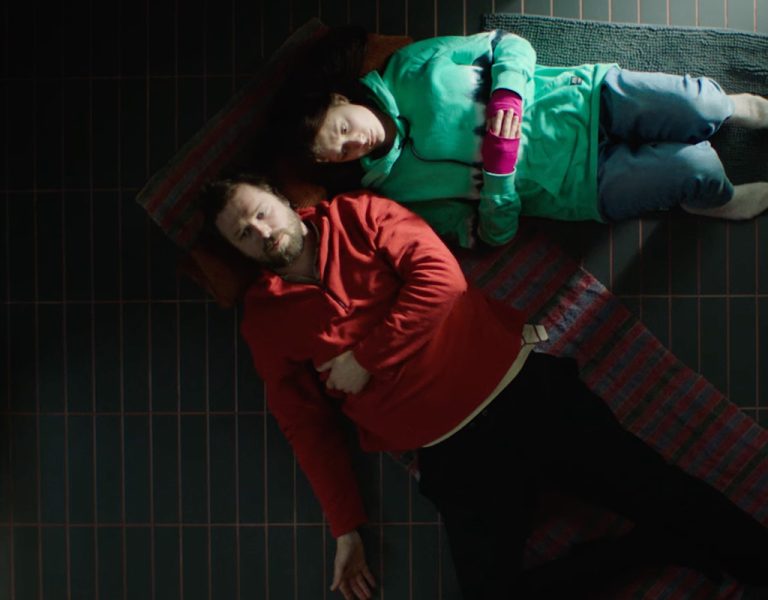 Two people lying on the ground together