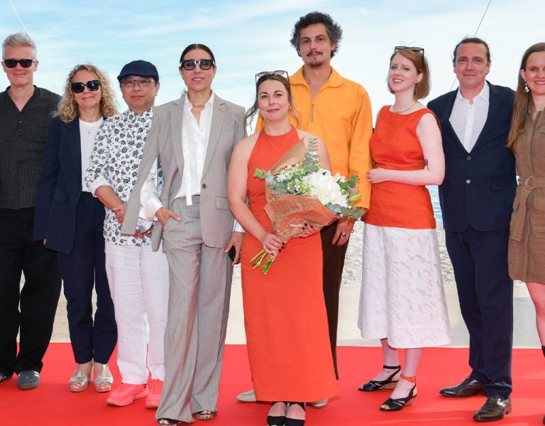 A group of people posing by the sea