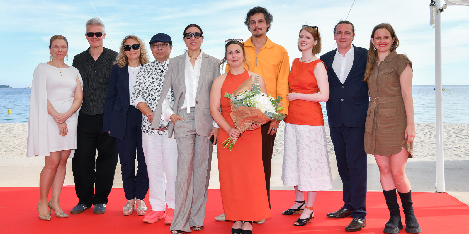 A group of people posing by the sea