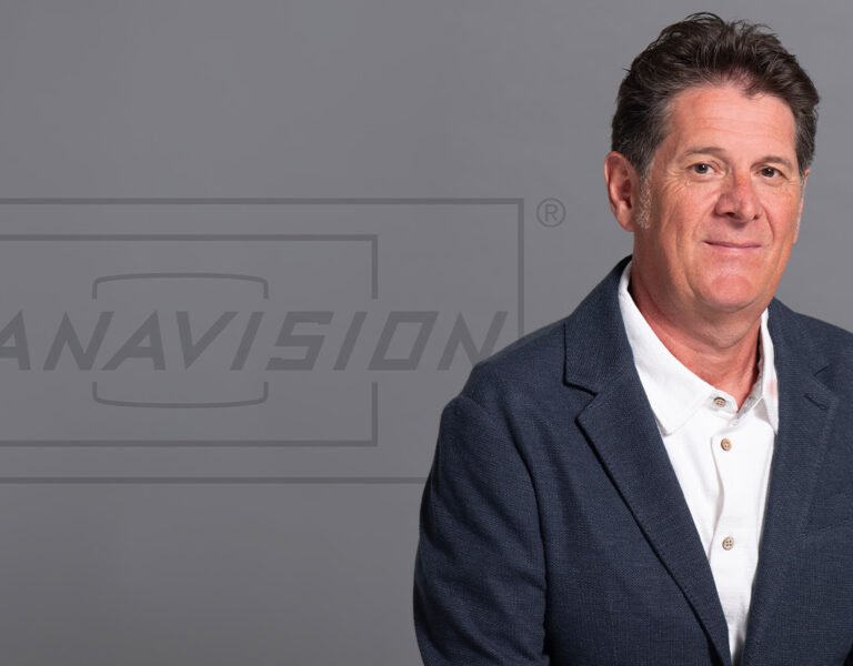 Heinzle sat in a suit looking into camera, with the Panavision logo behind