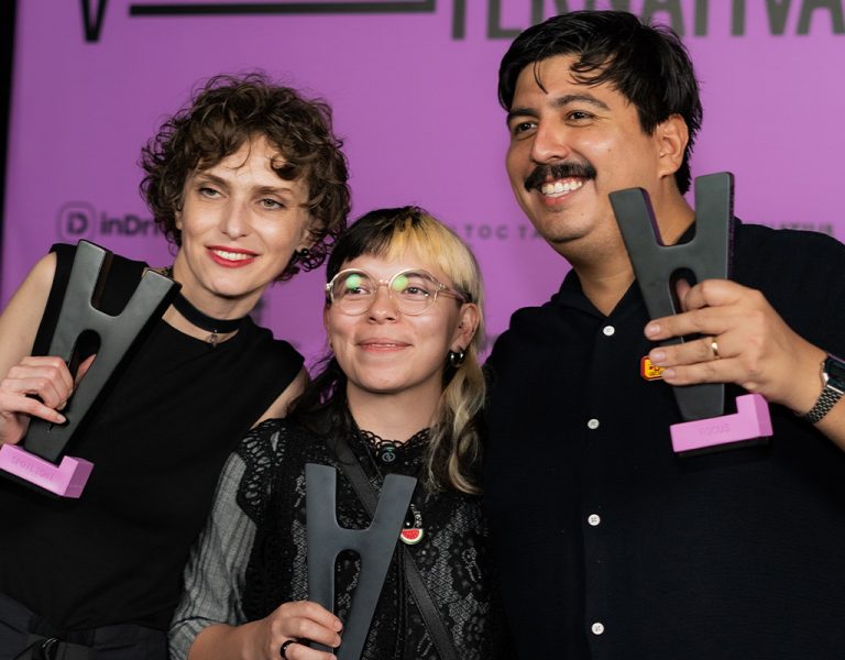 Three people posing with awards