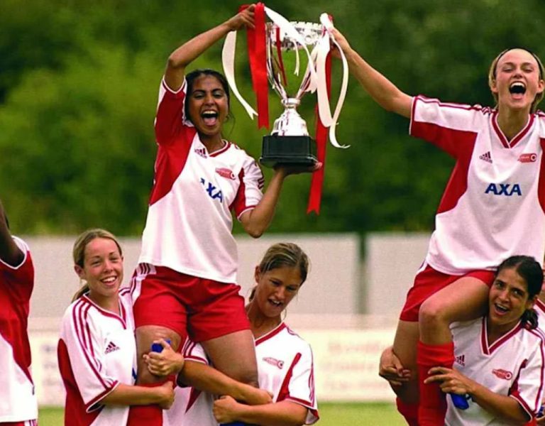 A group of girls celebrating in football kits