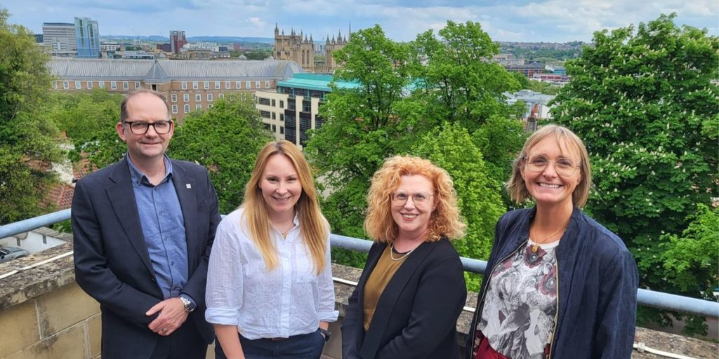 Four people stood with the Bristol skyline in the background