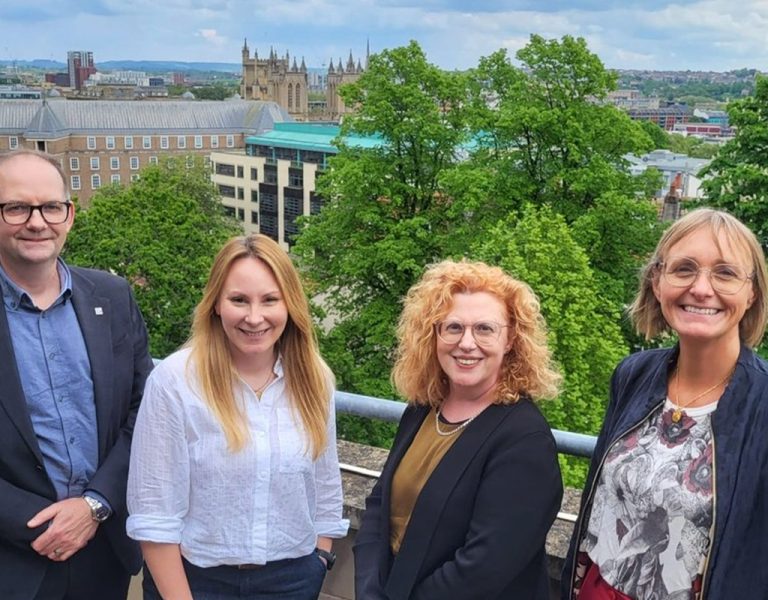 Four people stood with the Bristol skyline in the background