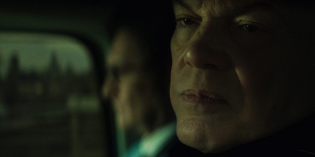 Two men sat in a dimly lit car