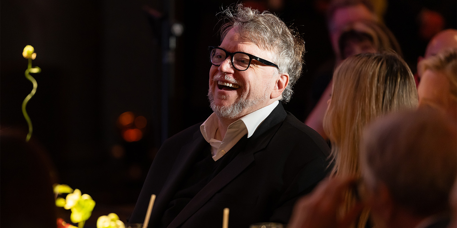 Guillermo del Toro laughing at a dinner table