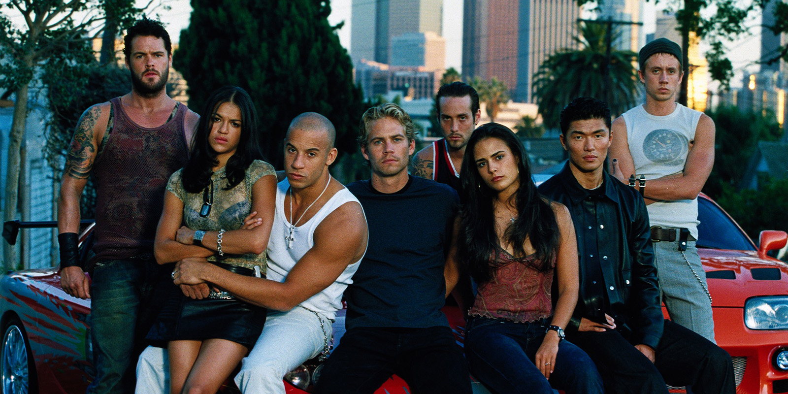 A group of people sat by a car