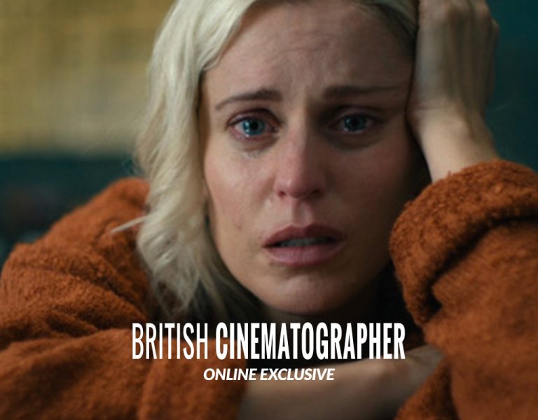 A distressed woman with short blonde hair and a tear-streaked face rests her head on her hand, wearing a rust-coloured jumper. The words British Cinematographer Online Exclusive are overlaid on the image.