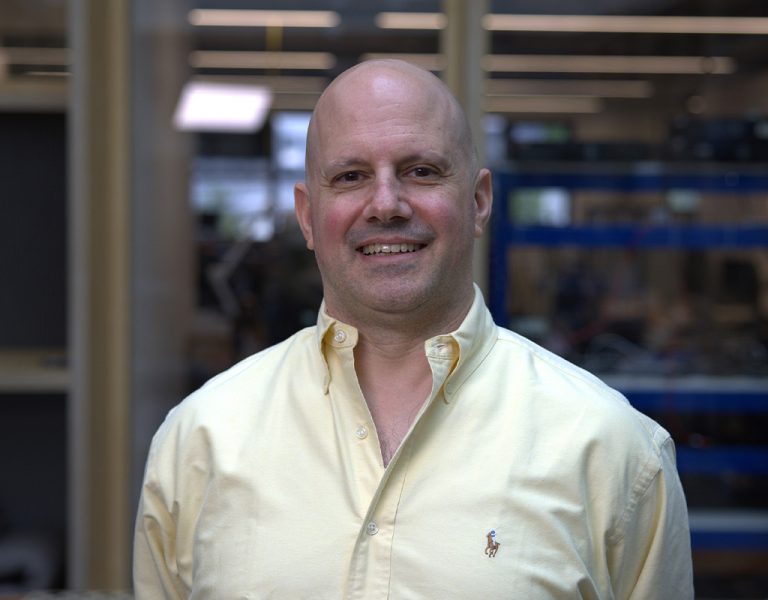 A man in a yellow shirt smiling