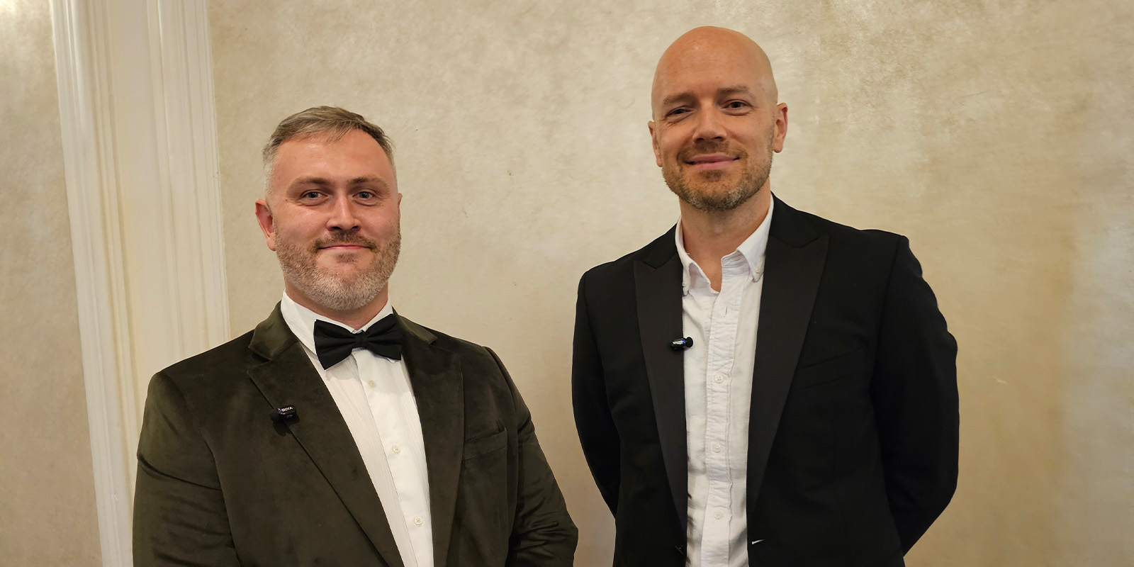Two men posing in tuxedos