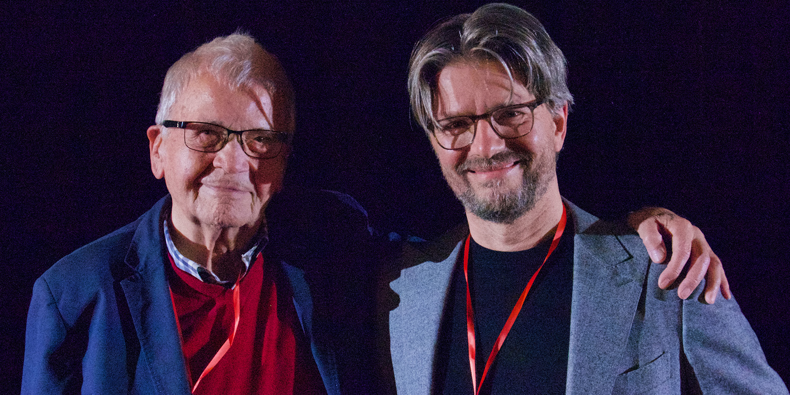 Two men smiling together into camera