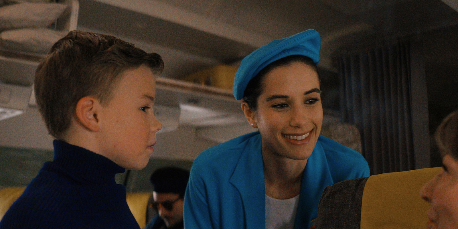 A boy and a flight attendant on a plane