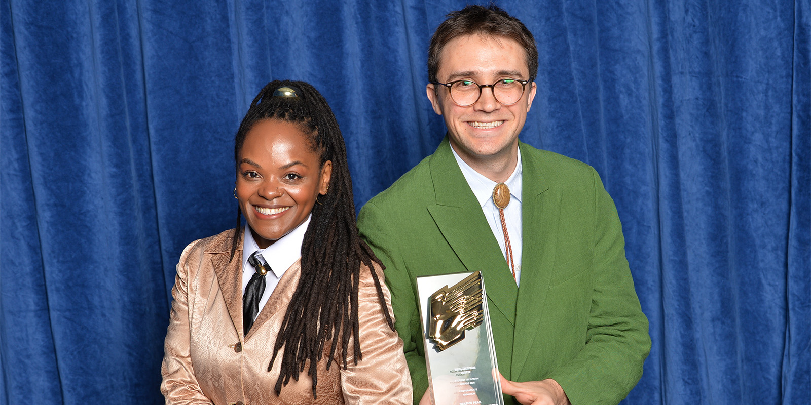 Two people posing with an award