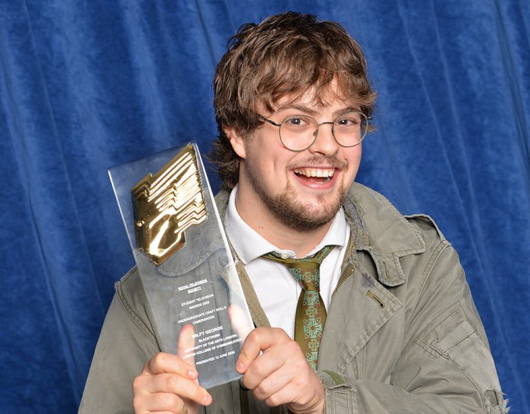 A man smiling with an award
