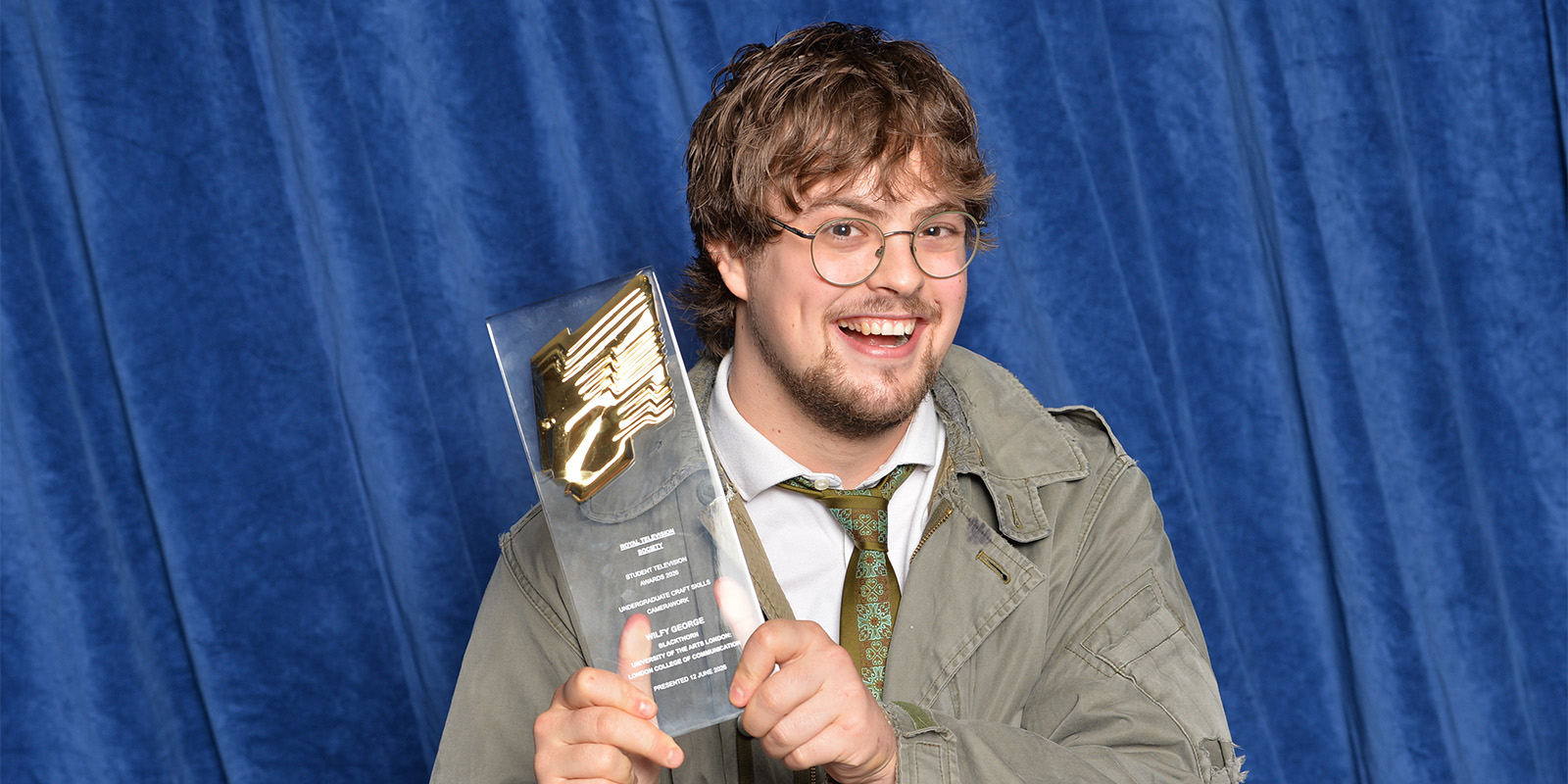 A man smiling with an award
