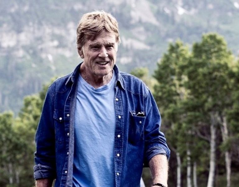 Robert Redford walking through a field
