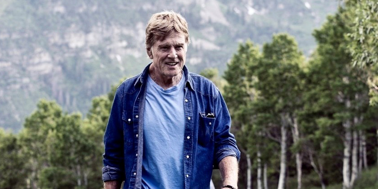 Robert Redford walking through a field