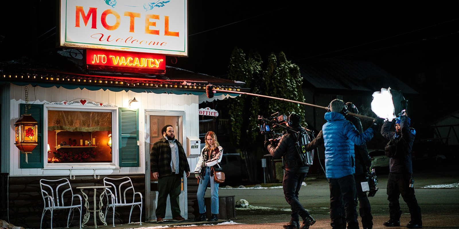 Cast and crew filming by a motel
