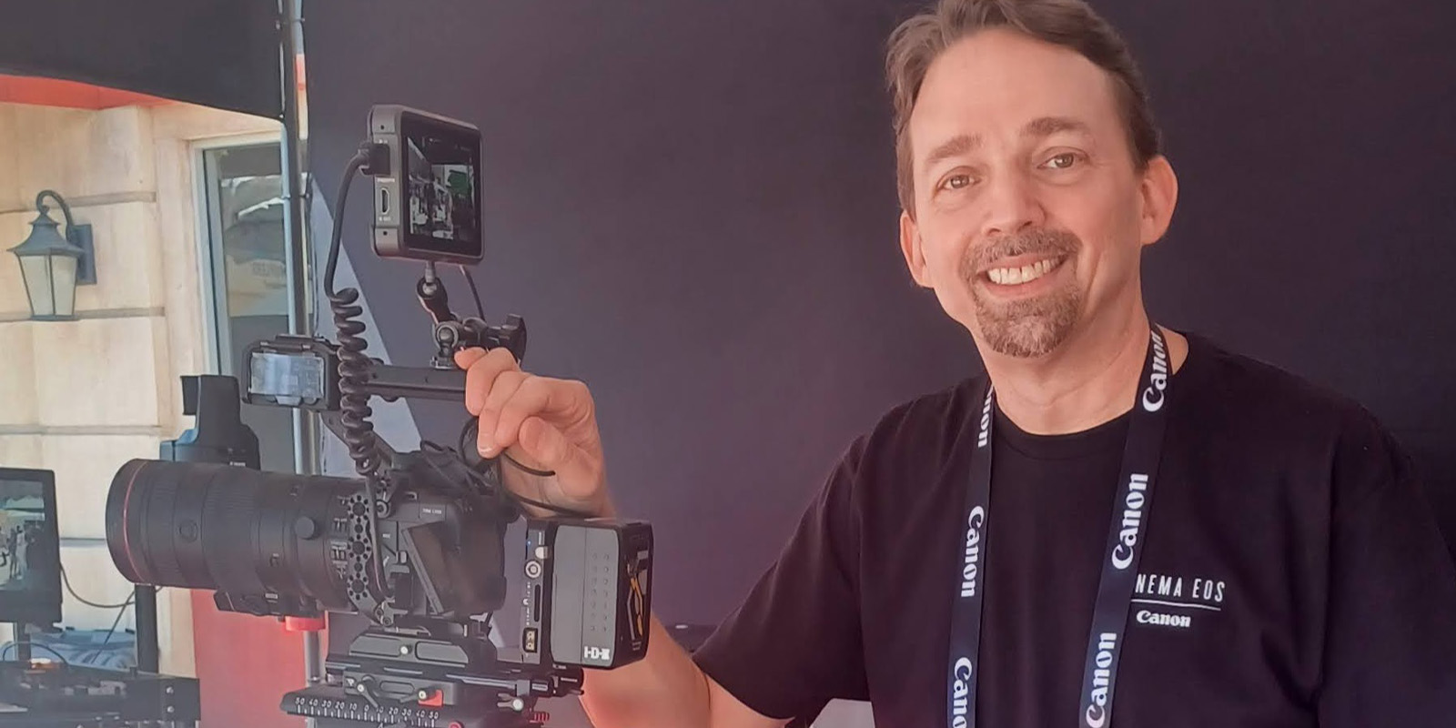A man posing by a camera