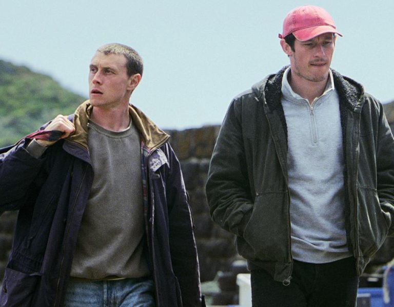 Two men stood by the sea