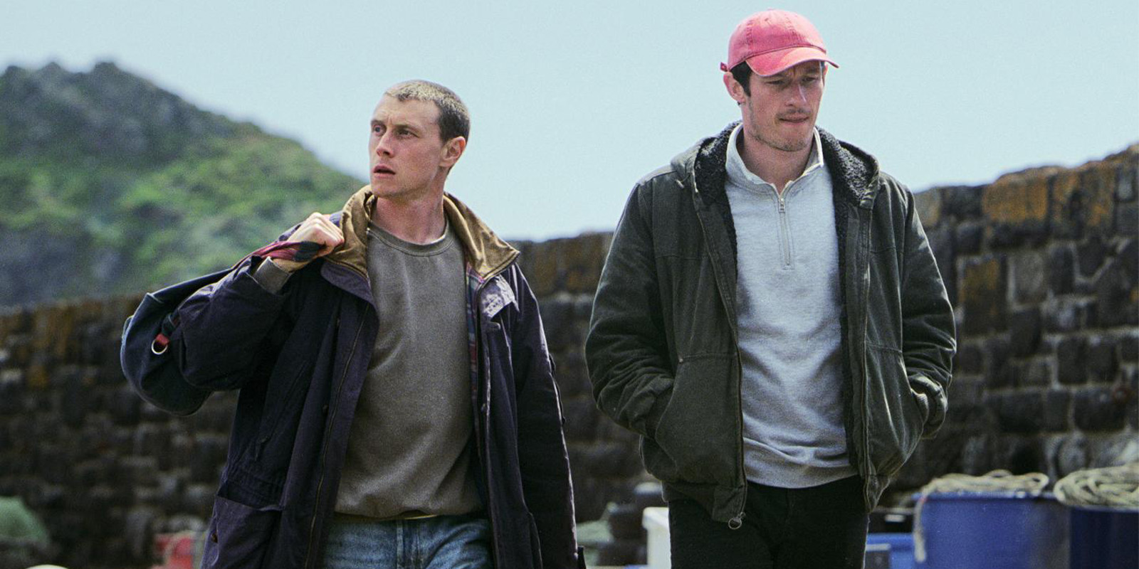 Two men stood by the sea
