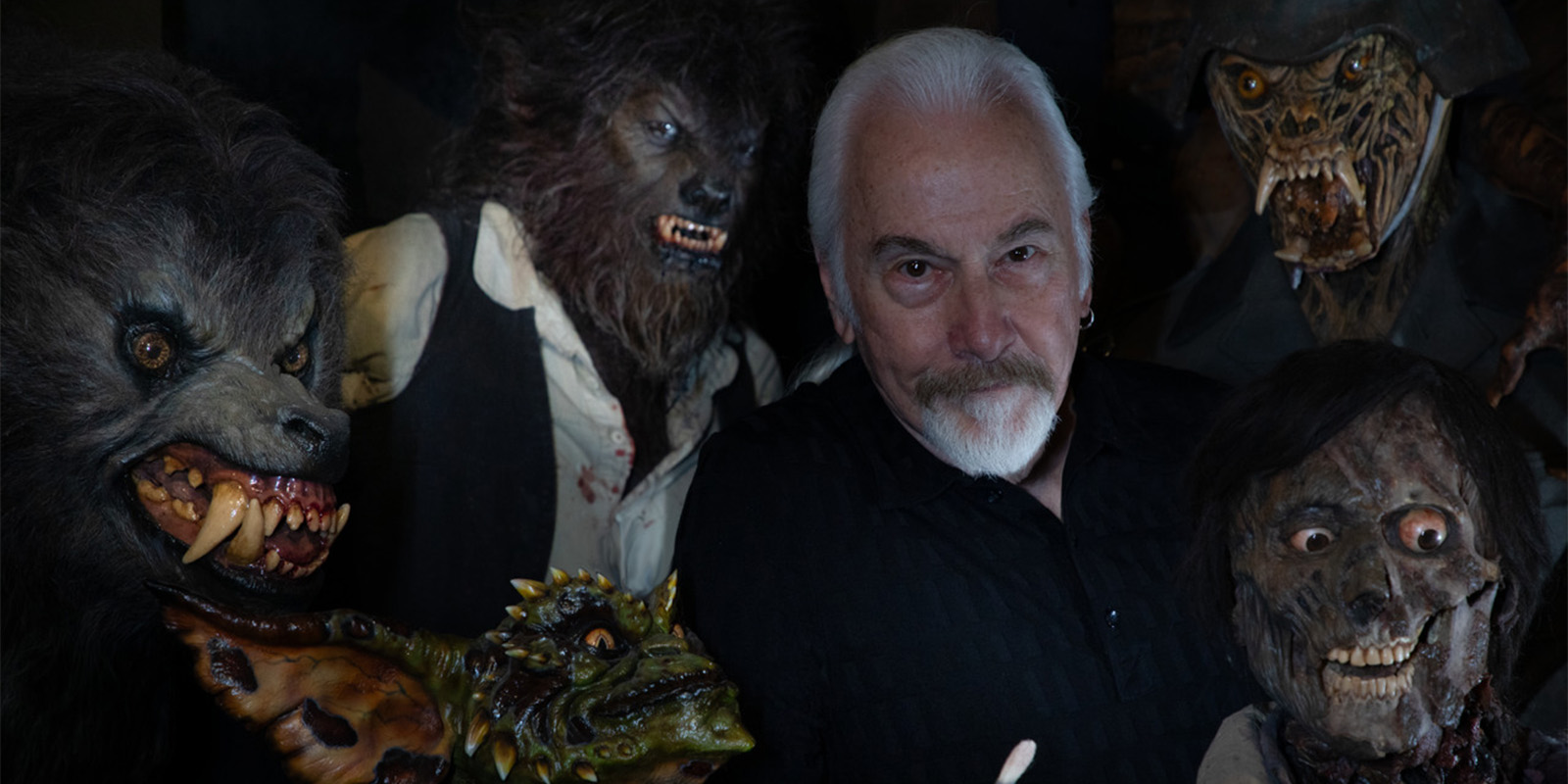 A man standing among wolf masks