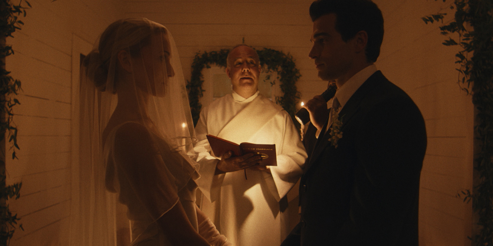 Two people and a priest at a wedding 