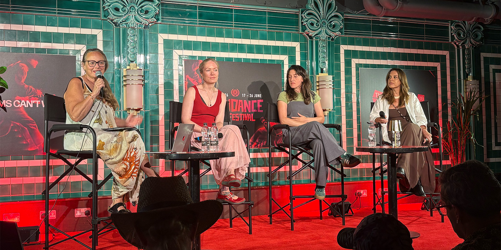 Four women sat talking on a panel