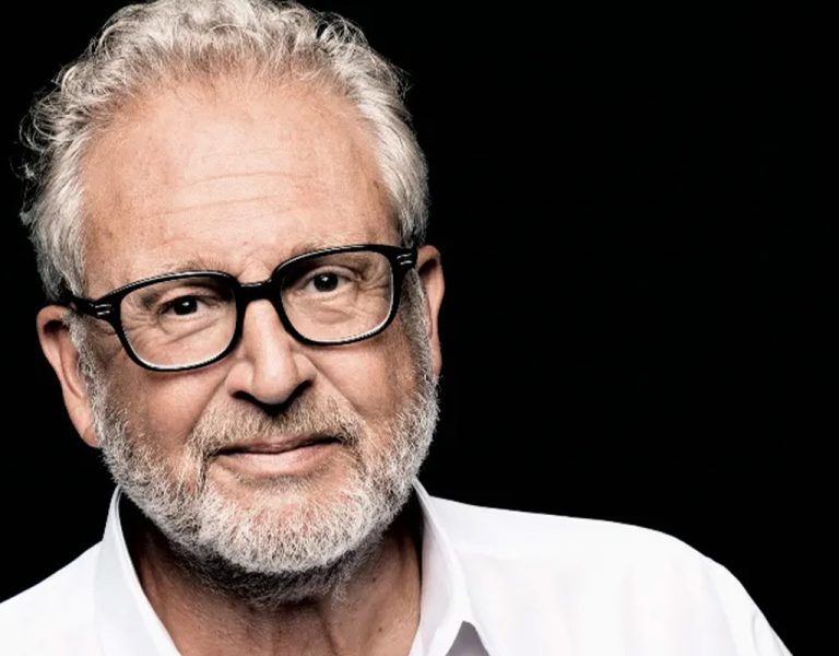 A man in a white shirt looking into camera