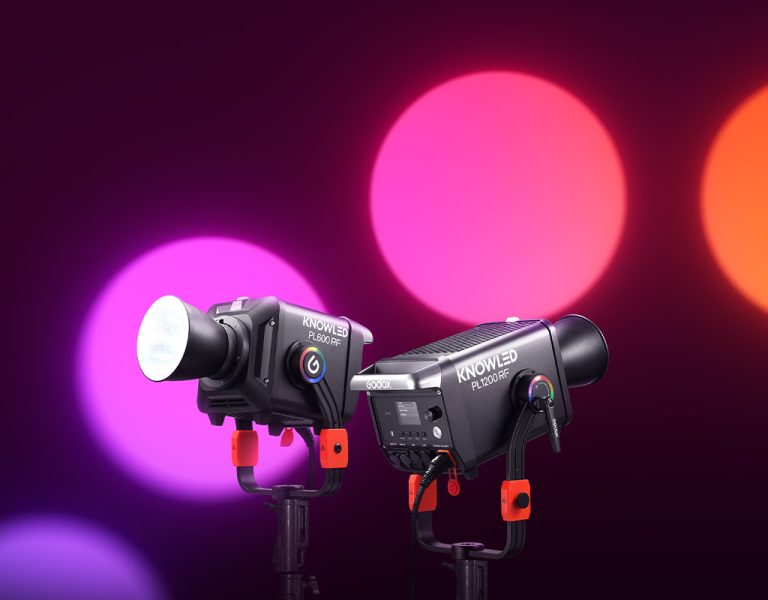 Two Godox lights against a red background