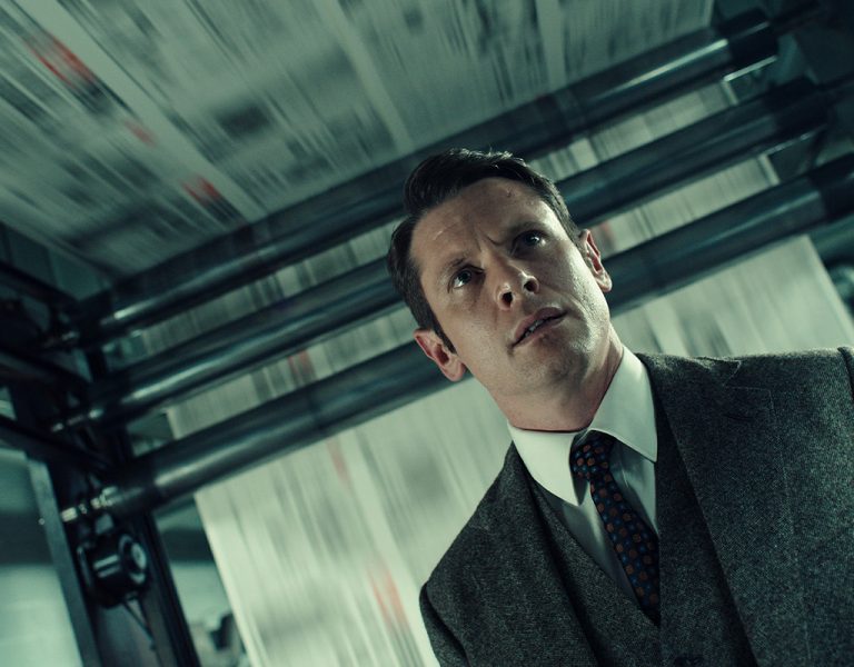 Jack O'Connell in a grey suit