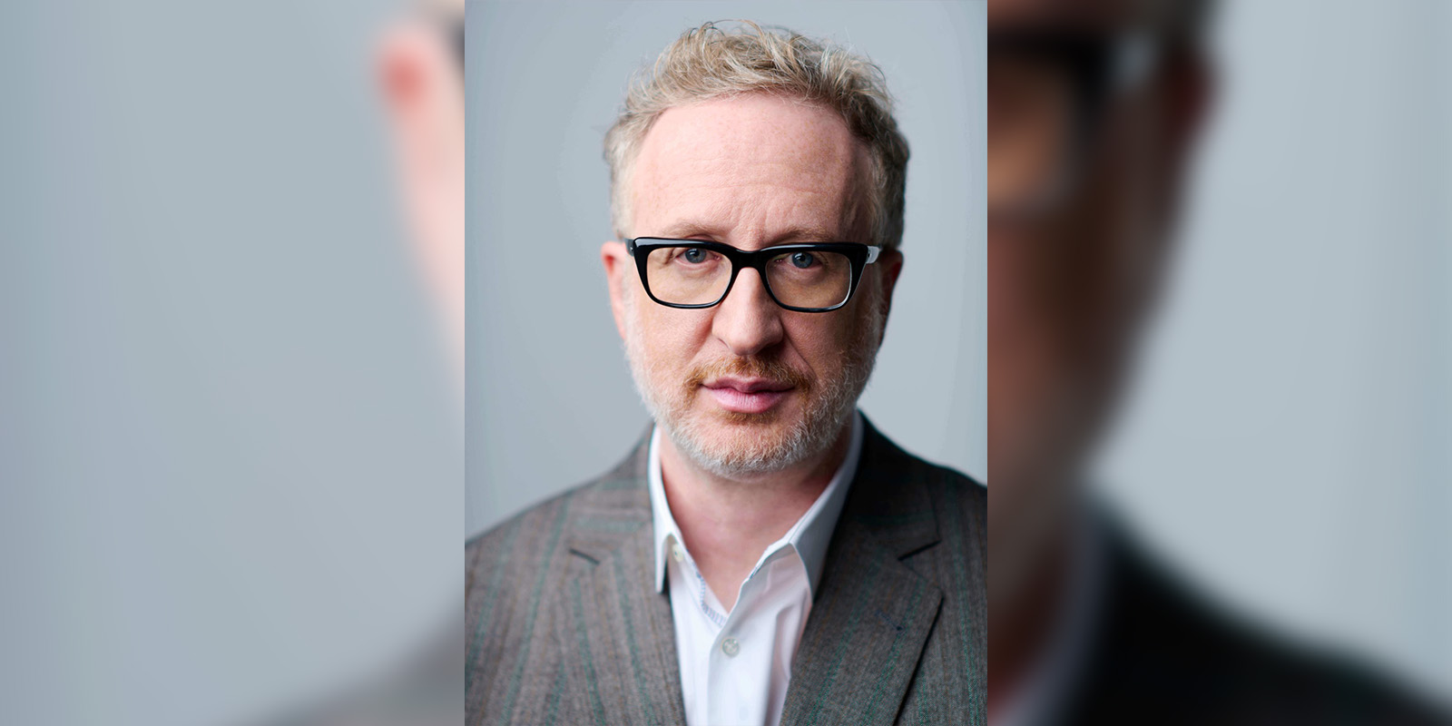 James Gray in a grey suit looking into camera