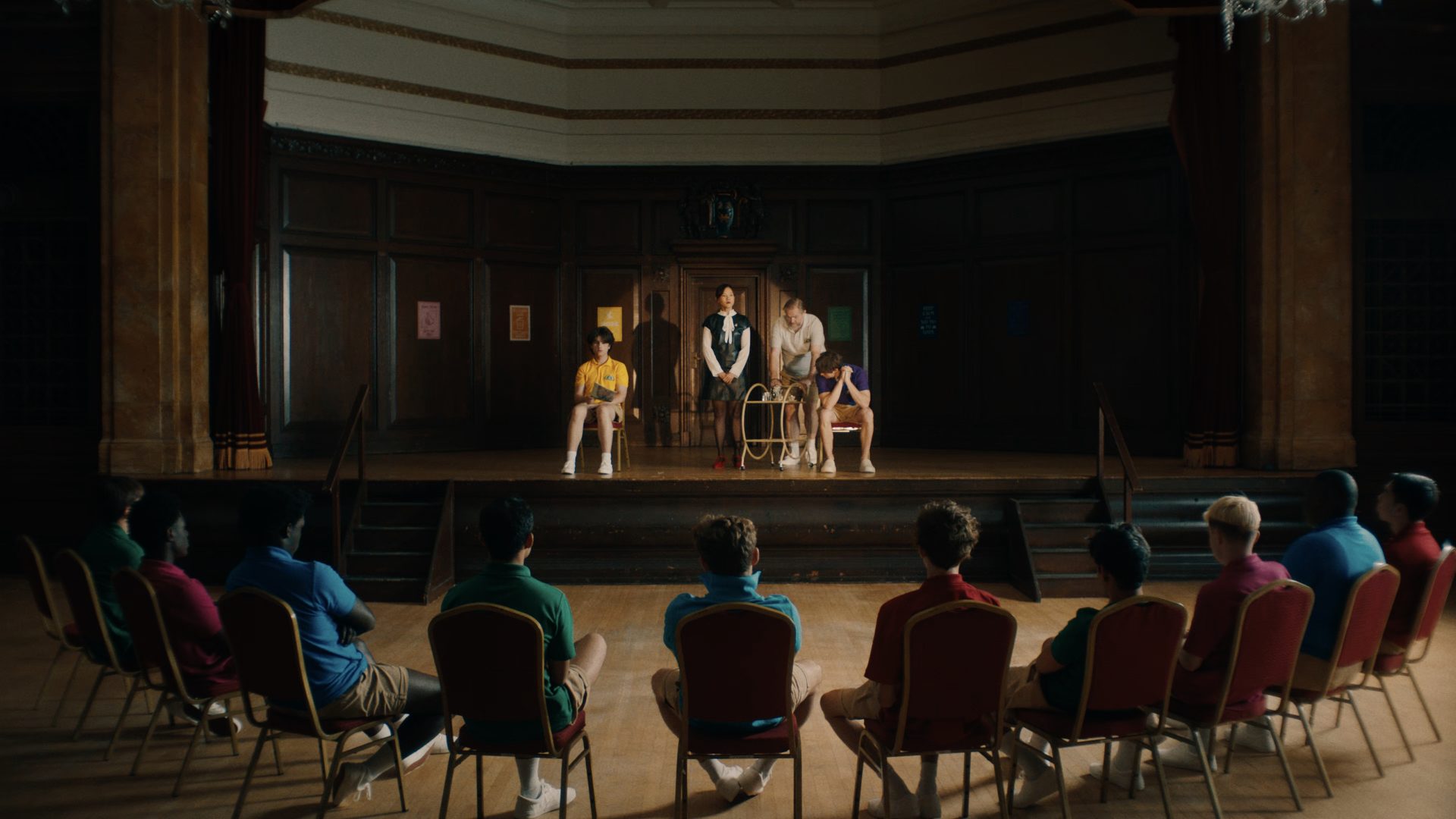 A group of students watching people on a stage