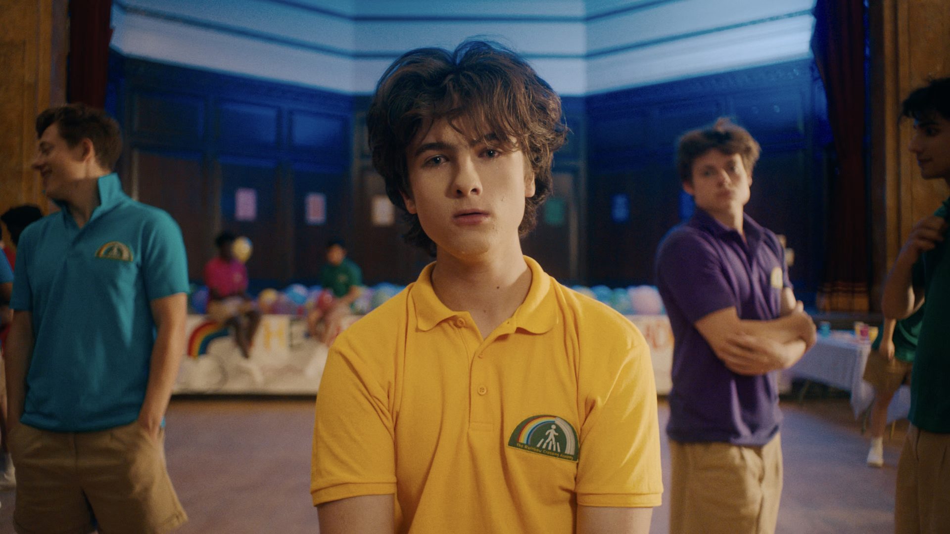 A boy in a yellow shirt looking sad