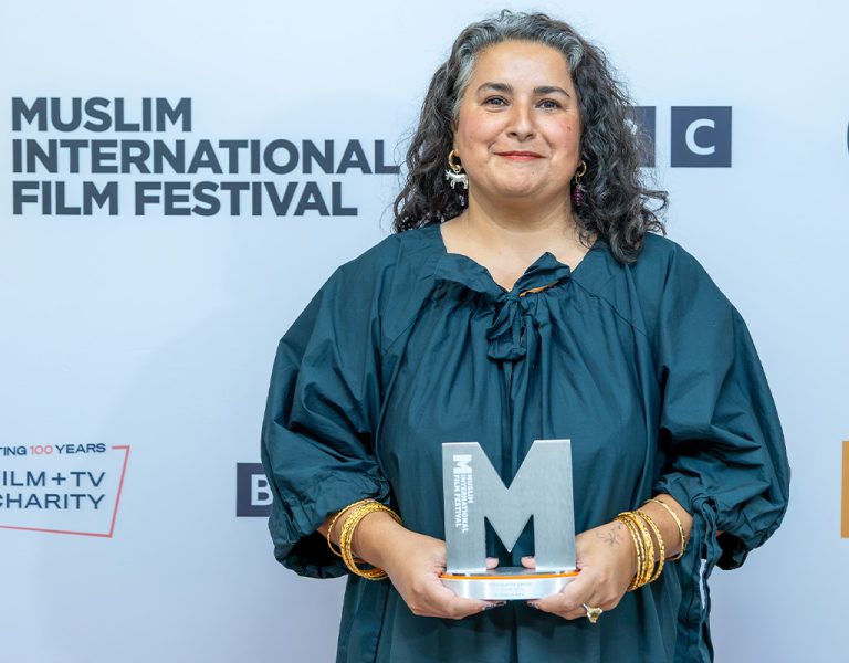 Shaheen Baig holding an M-shaped trophy