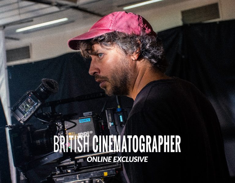 A man in a red cap behind a camera