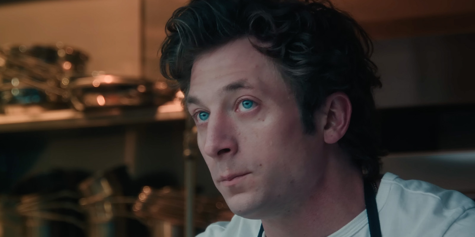 Carmy from The Bear in a kitchen looking stressed