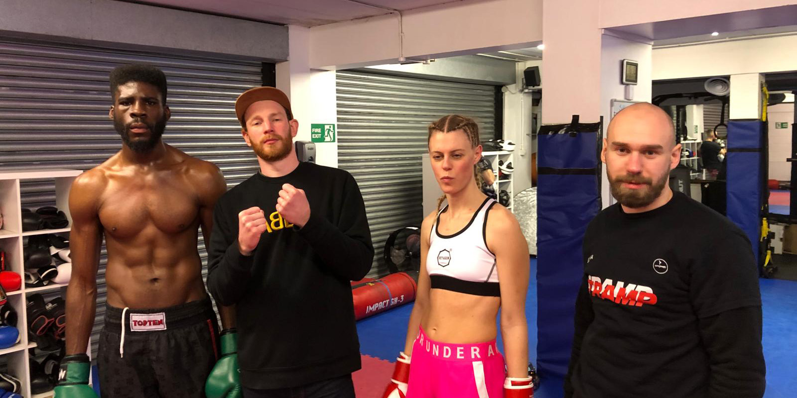 Cast and crew posing in a boxing gym