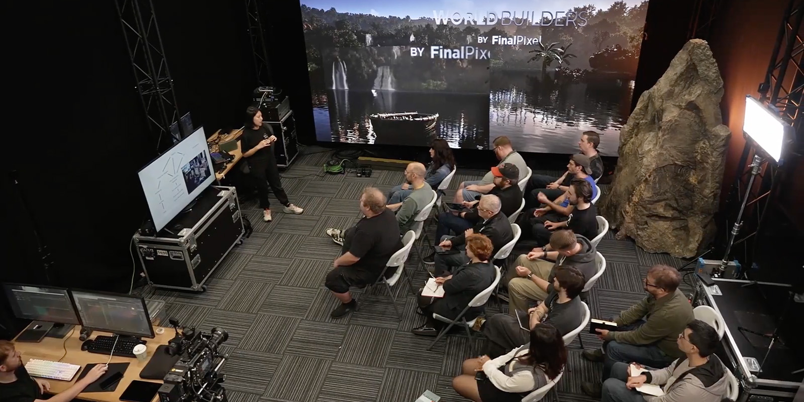 A group of people sat listening to a talk on a VP set