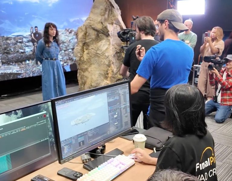People gathered around using virtual production equipment