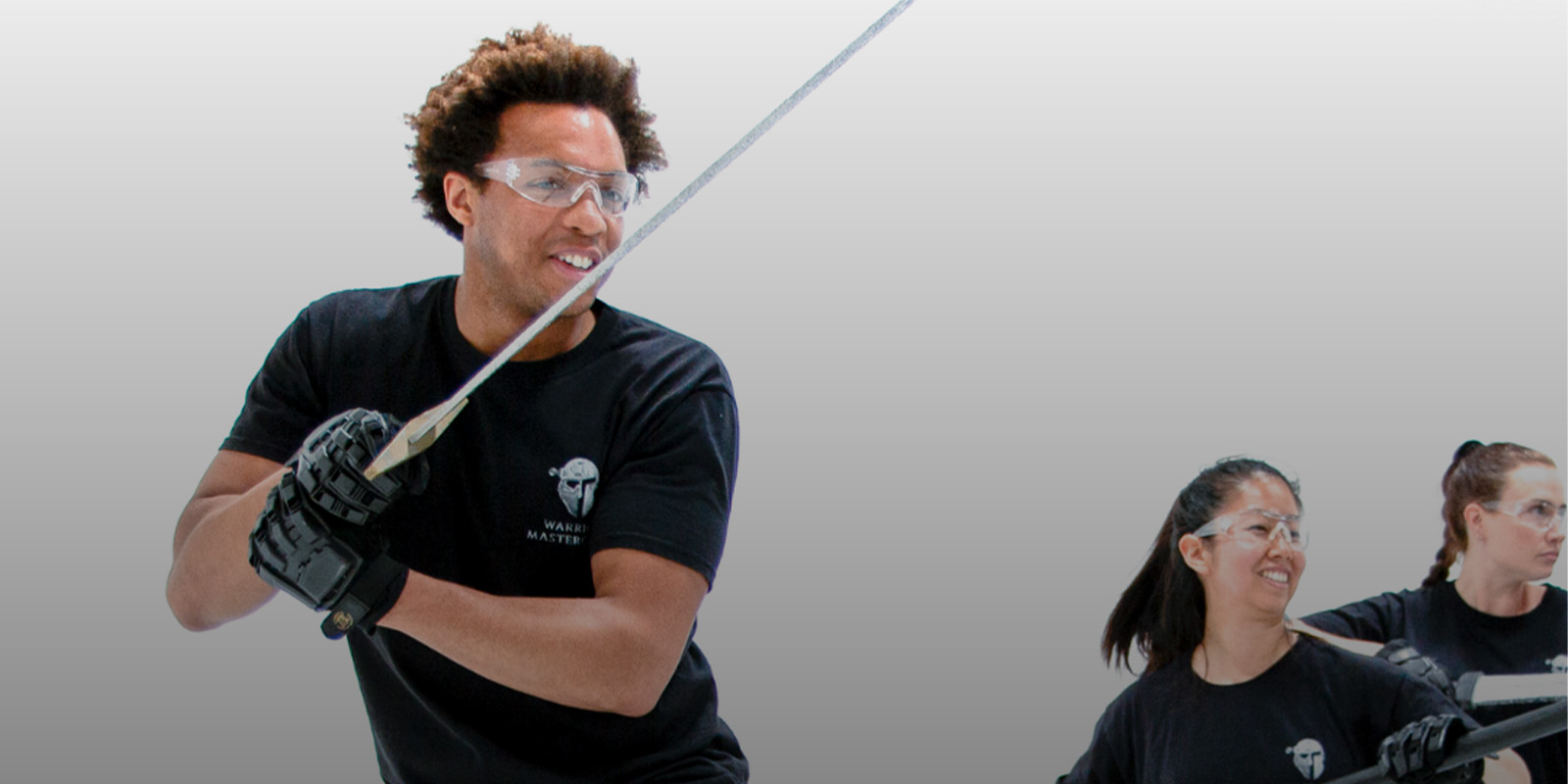 Three people wielding swords and smiling