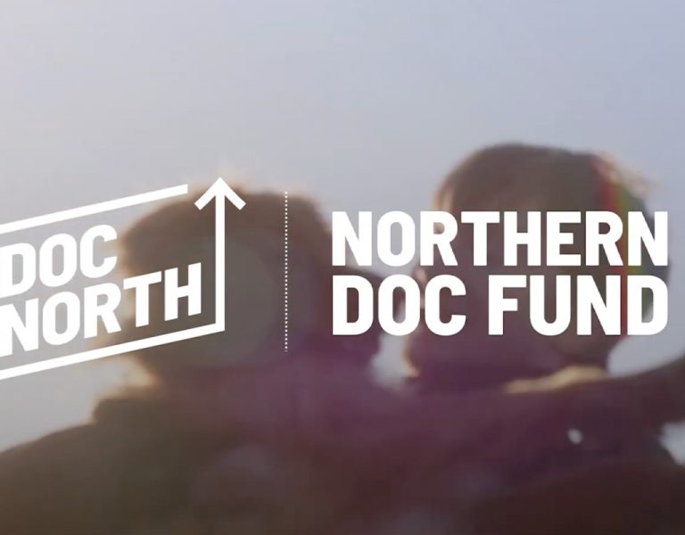 A man holding a dog behind the Doc North logo