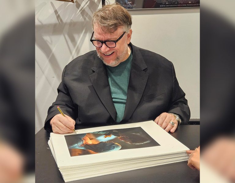 Guillermo del Toro smiling and signing photographs