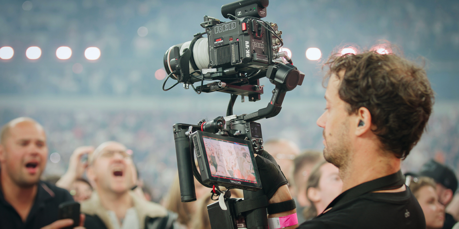 A man using a large camera to record crowds