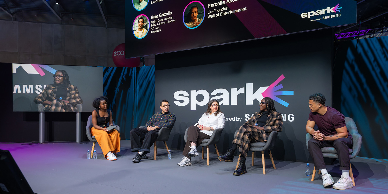 A group of people sat in conversation on a stage