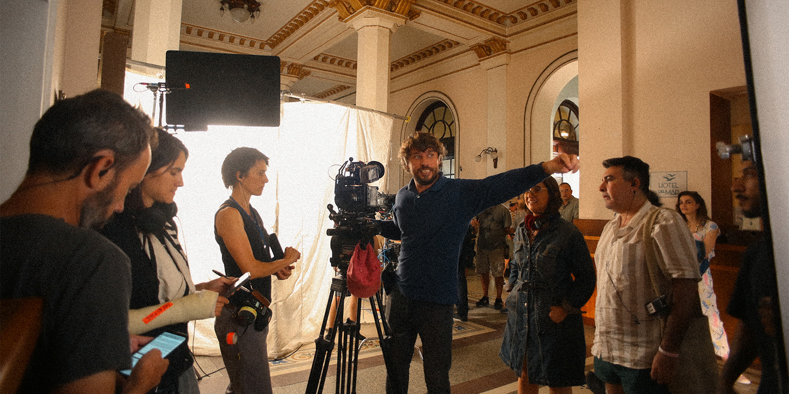 Film crew on set with a man pointing