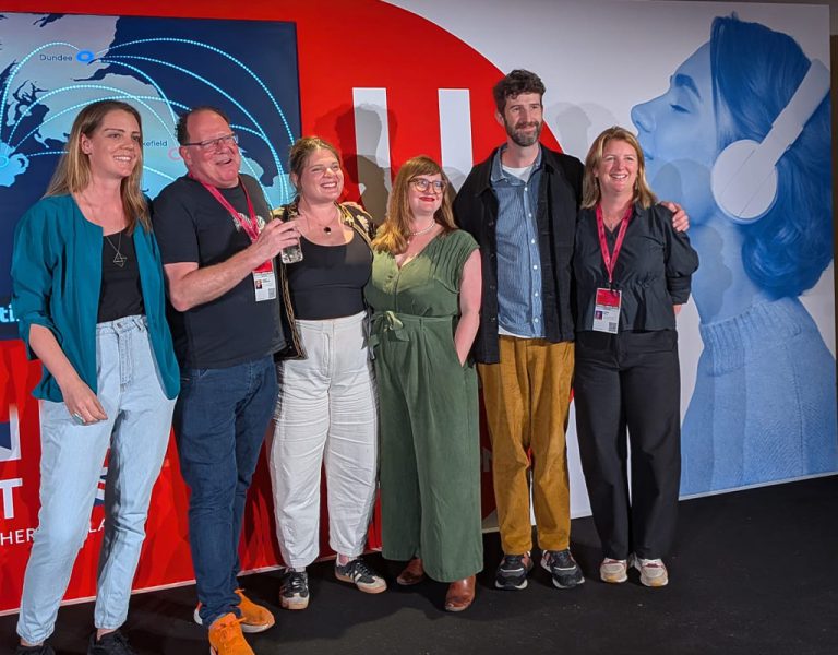 People posing together on stage